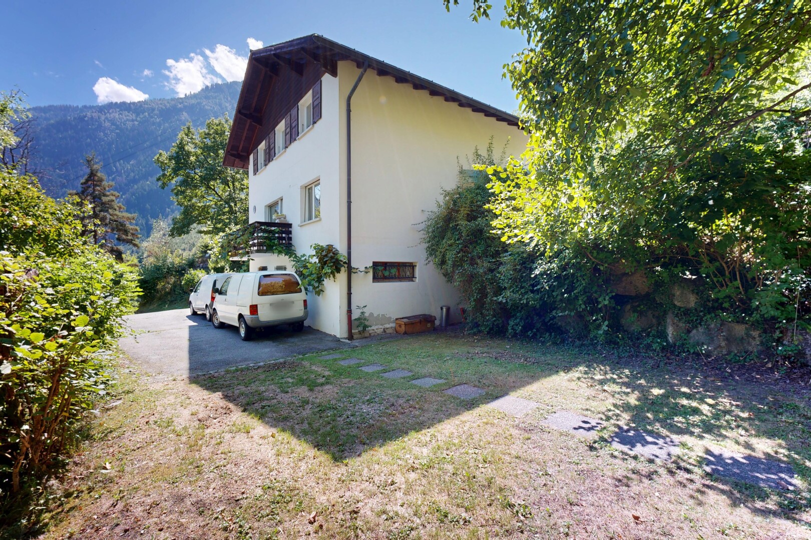 façade avec property visible, day time, aire de stationnement, pelouse, et vue sur la montagne