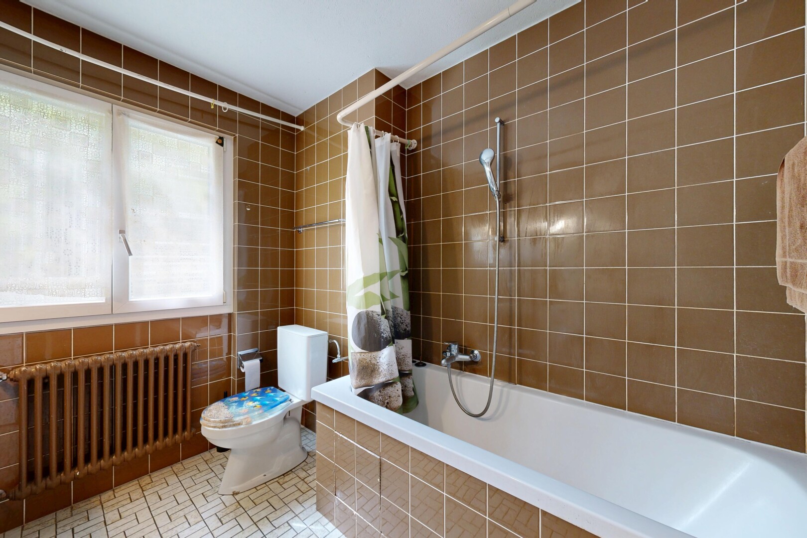 salle de bains avec mur en carrelage, tile wall, radiateur, douche-bain combinés, et salle de bain complète