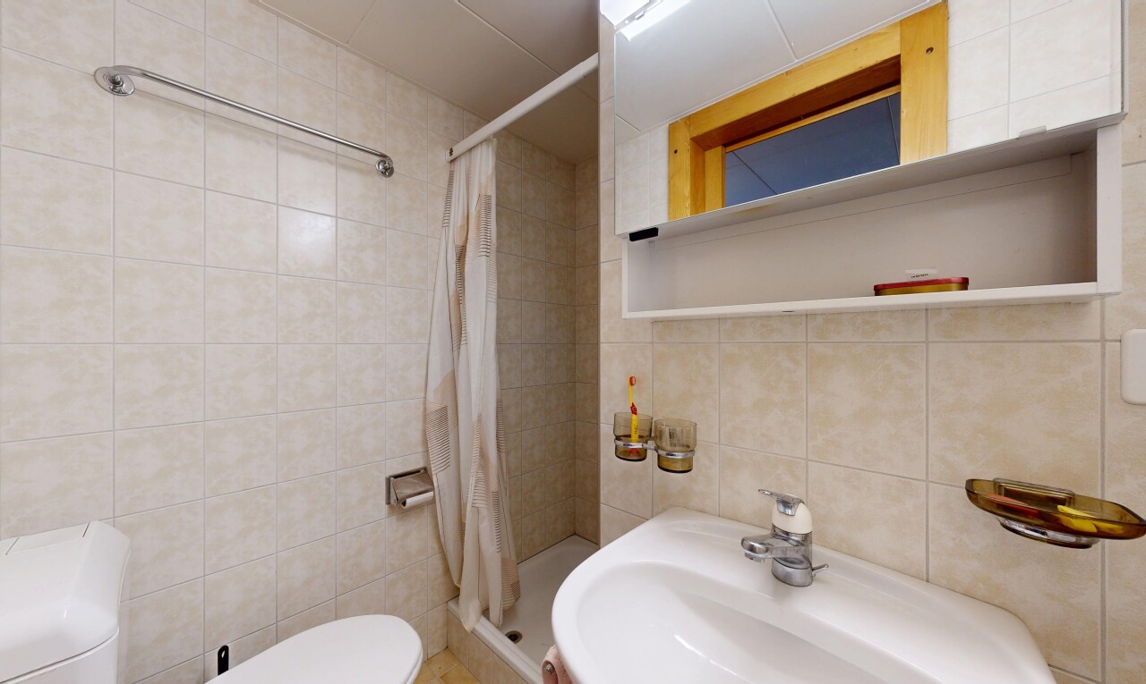 salle de bains avec tile wall, mur en carrelage, toilette, tile shower, et inside property