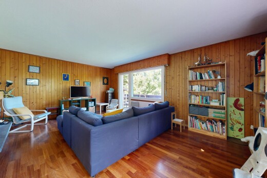 salon avec inside property, sol en finition bois, wood finish floor, télévision, et lumière naturelle