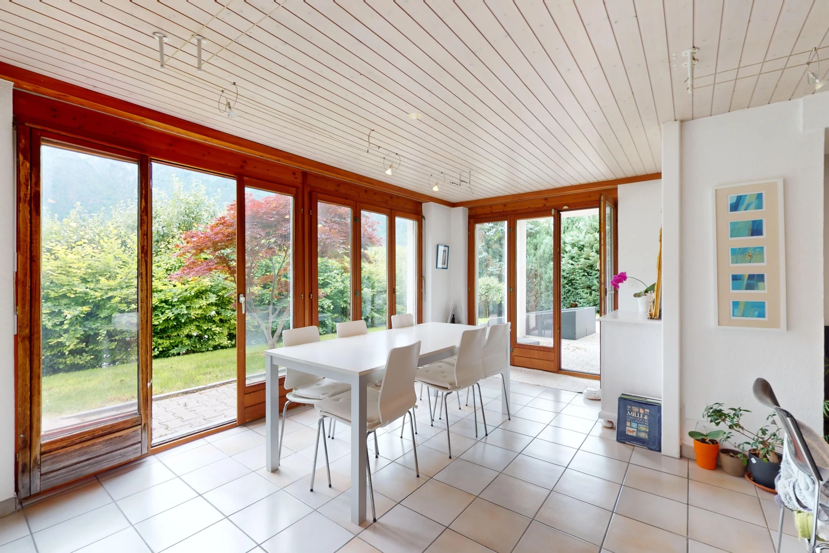 salle à manger avec carrelage, plafond de bois, et lumière naturelle