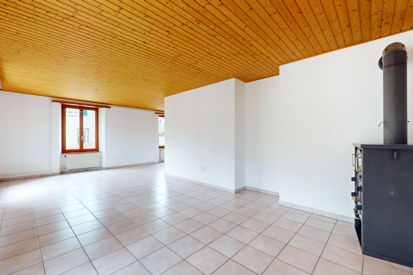 pièce vide avec plafond de bois, lumière naturelle, radiateur, et carrelage