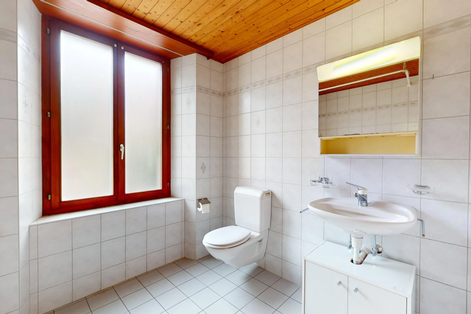 salle de bain avec plafond de bois, lumière naturelle, carrelage, et mur carrelé