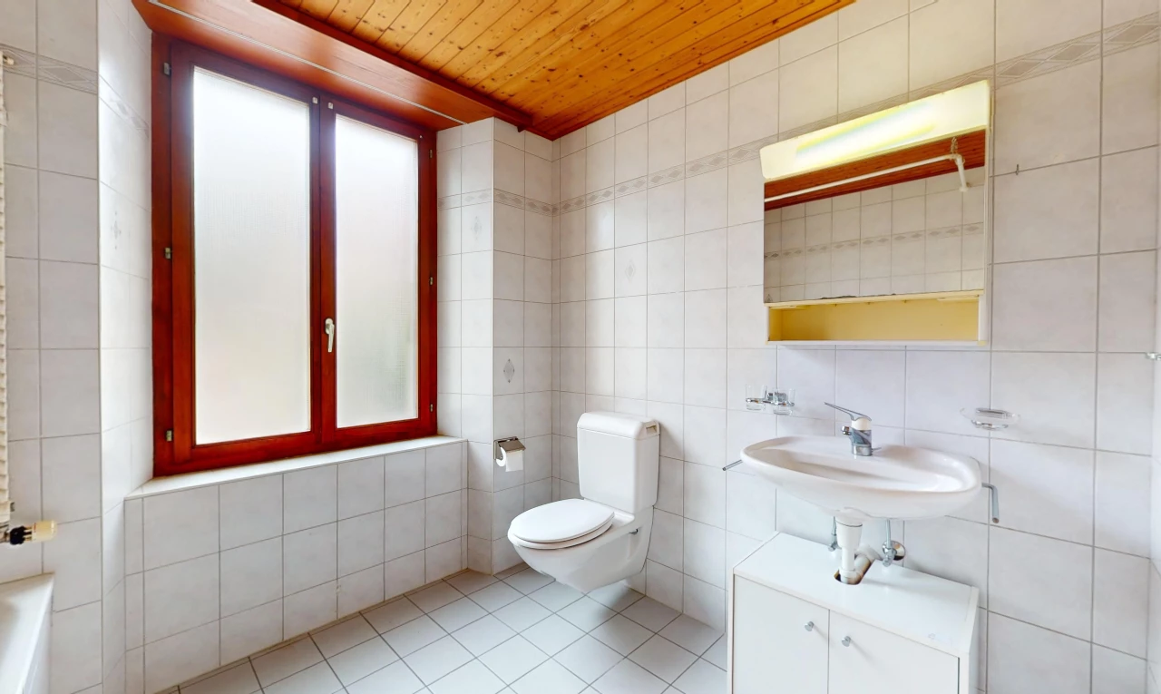 salle de bain avec plafond de bois, lumière naturelle, carrelage, et mur carrelé