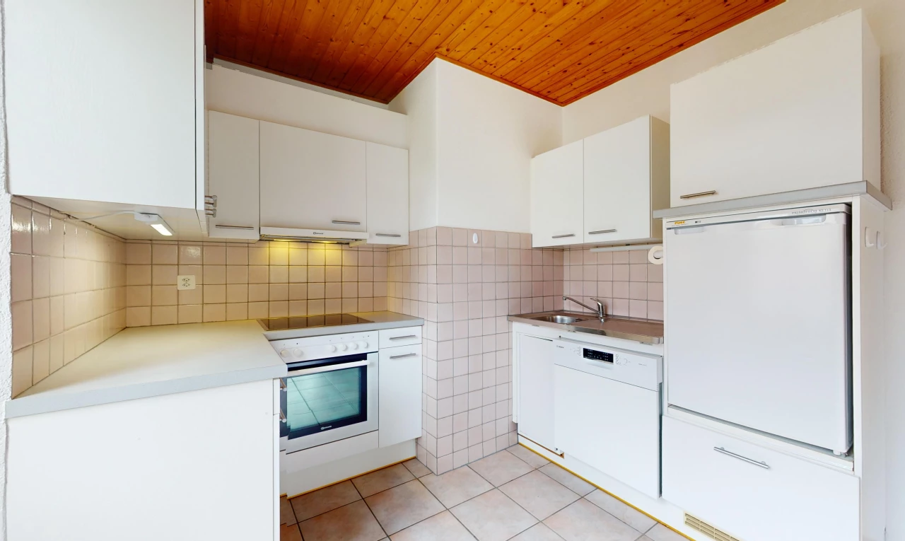 cuisine avec plafond de bois, hotte, four, meubles blancs, et crédence