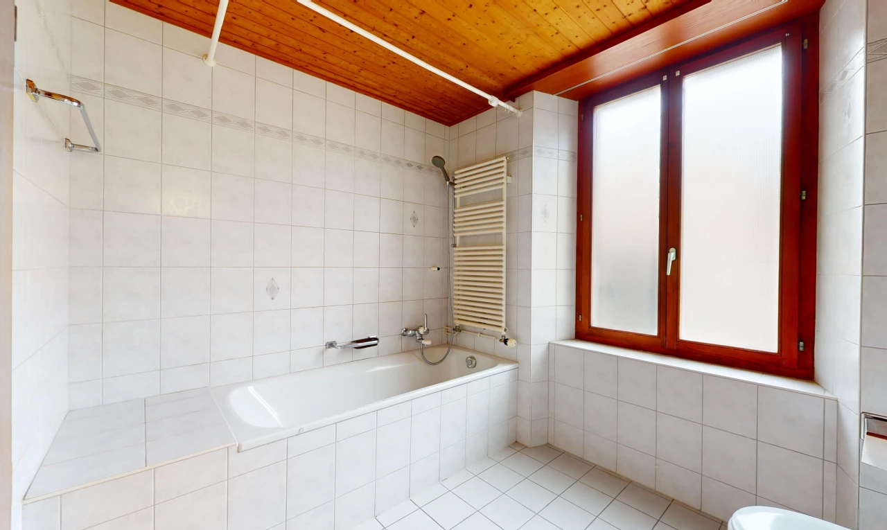salle de bain avec bain-douche, radiateur, plafond de bois, et lumière naturelle
