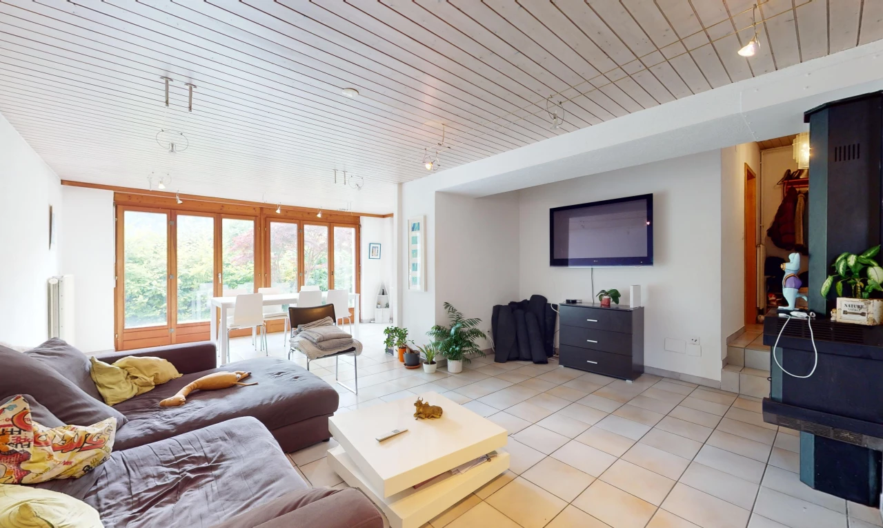 salon avec lumière naturelle, carrelage, et télévision