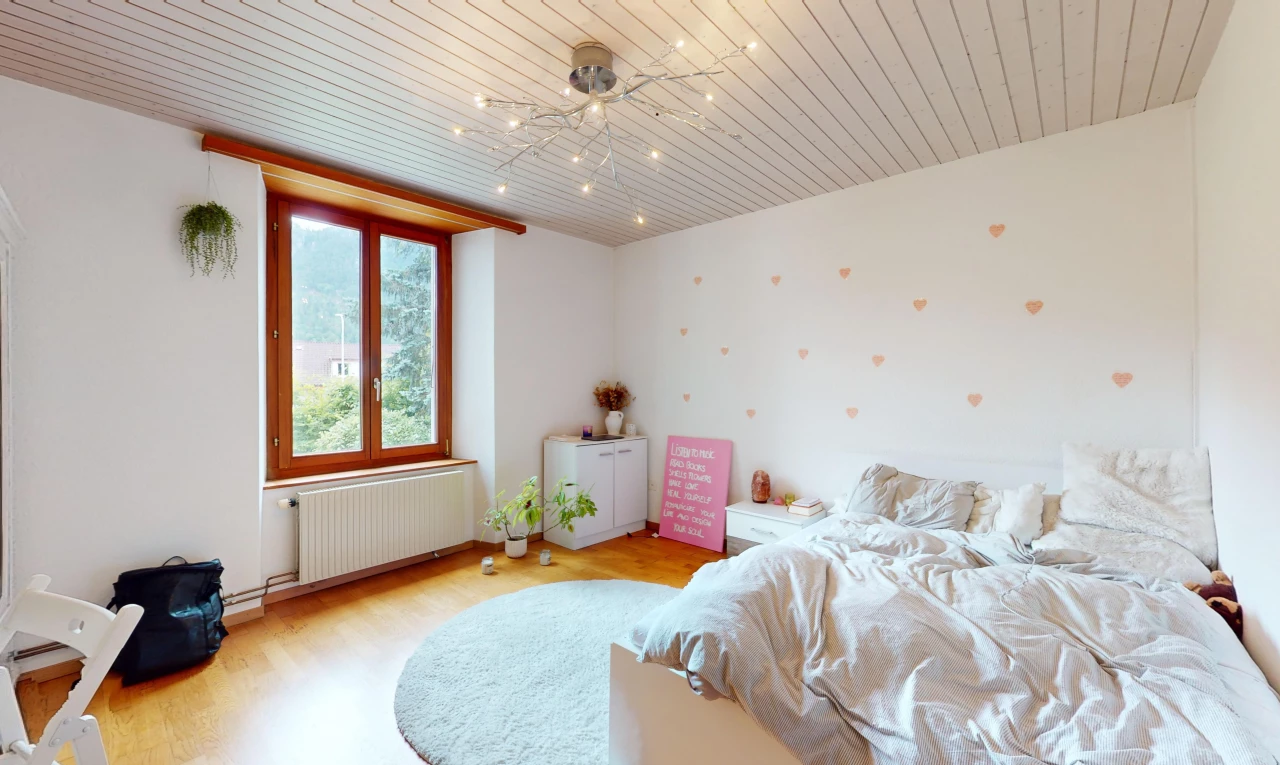 chambre avec plancher de bois, radiateur, et lumière naturelle