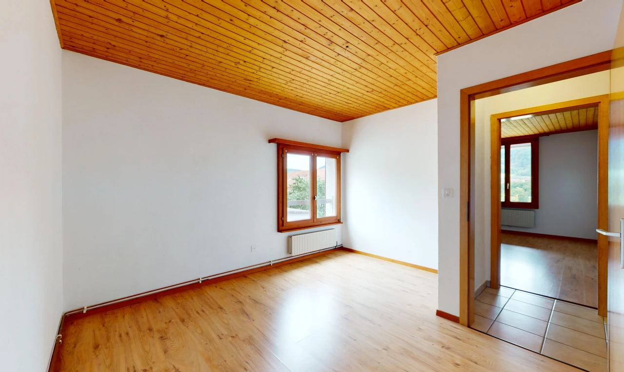 pièce vide avec plancher de bois, radiateur, plafond de bois, et lumière naturelle