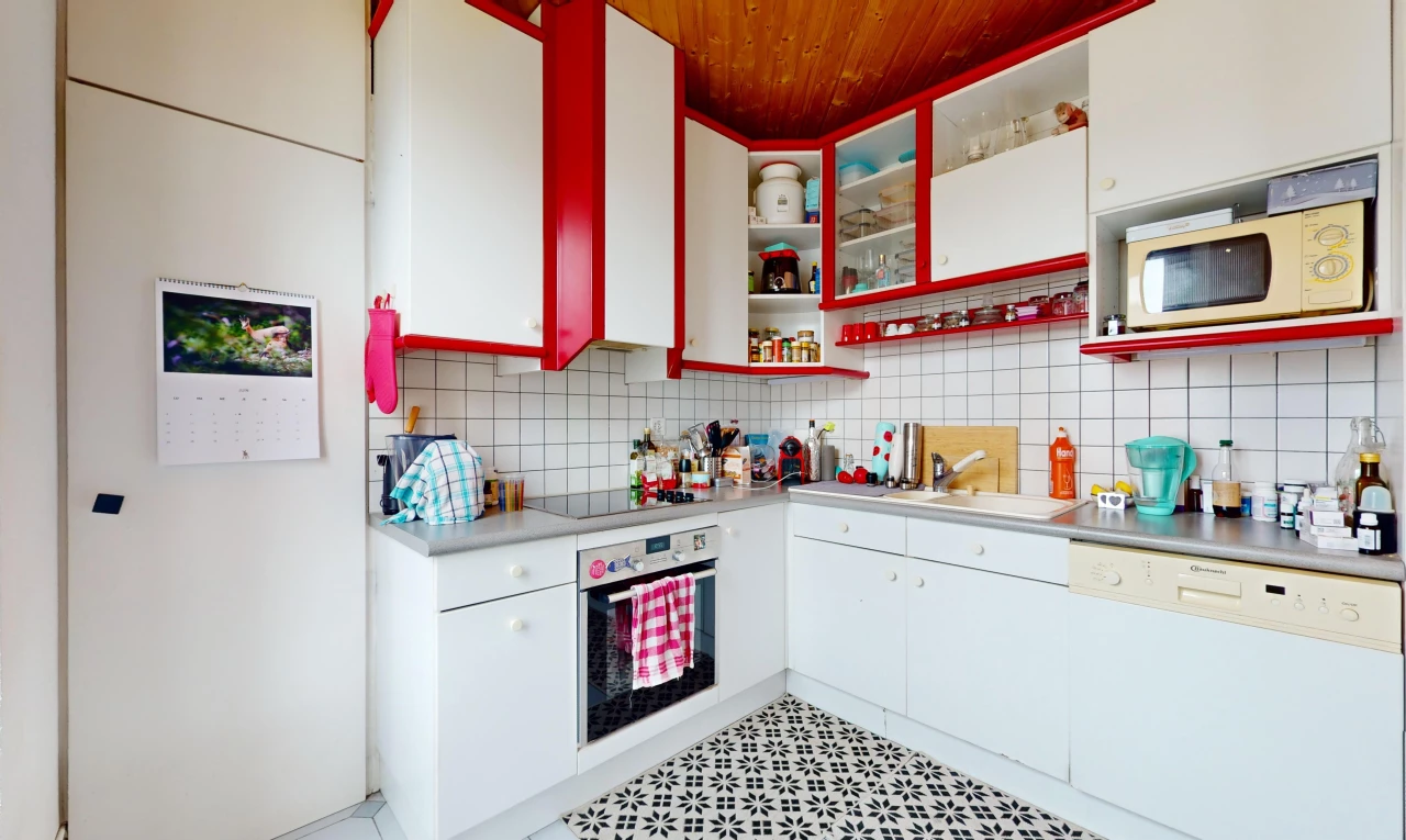 cuisine avec lave-vaisselle, carrelage, plan de travail, meubles blancs, et four