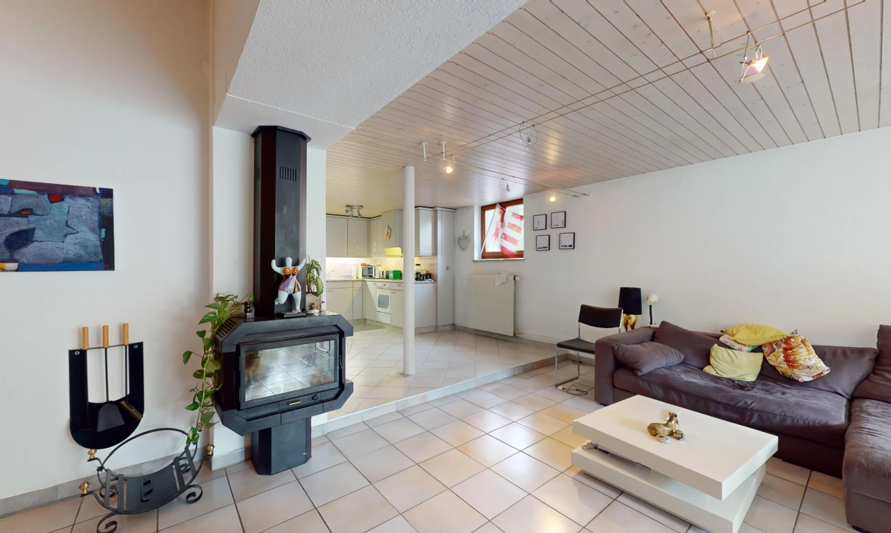 salon avec carrelage, lumière naturelle, et poêle à bois