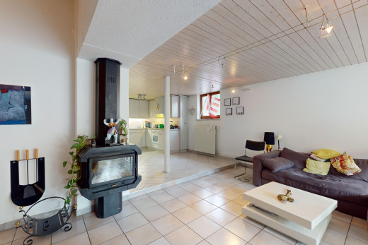 wohnzimmer mit fliesenboden, natürliches licht, und holzofen