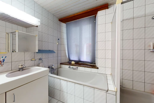salle de bain avec baignoire, meuble-lavabo, vasque, miroir, et mur carrelé