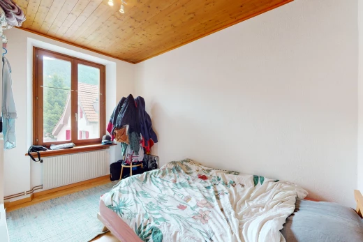 chambre avec plafond de bois, radiateur, et lumière naturelle