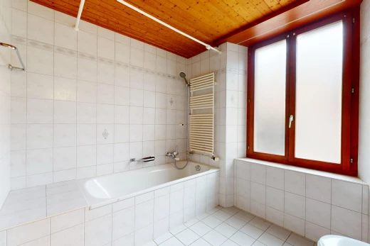 salle de bain avec bain-douche, radiateur, plafond de bois, et lumière naturelle