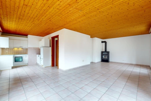 pièce vide avec plafond de bois, poêle à bois, et carrelage