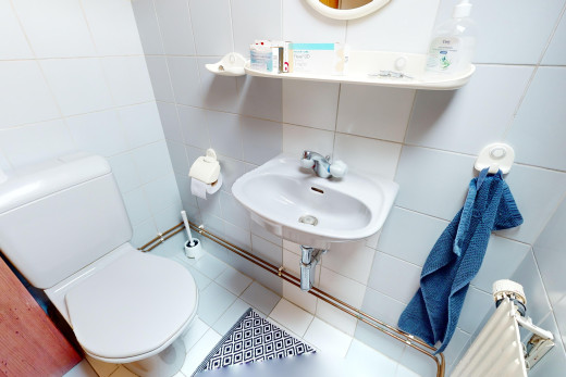 bad mit spiegel, toilette, waschbecken, fliesenboden, und fliesenwand