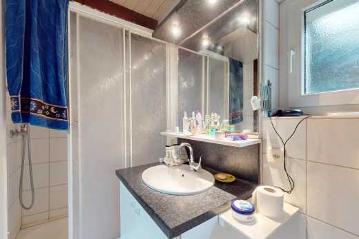 salle de bain avec meuble-lavabo, miroir, lumière naturelle, et vasque