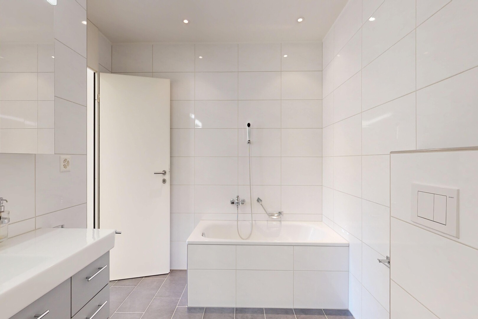 salle de bains avec mur en carrelage, tile wall, lavabo (ou coiffeuse selon le contexte), bain, et salle de bain complète