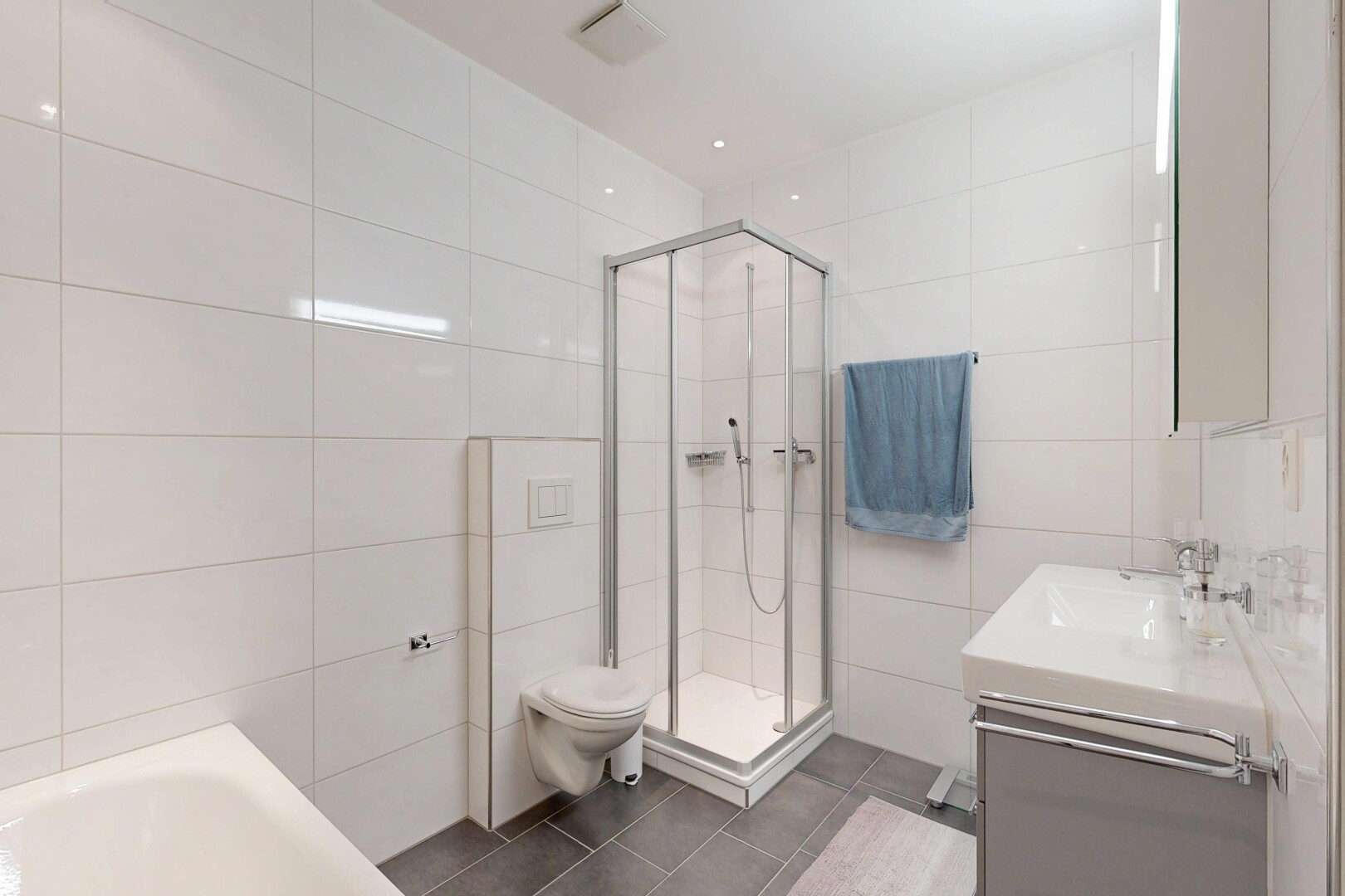 salle de bains avec salle de bain complète, mur en carrelage, tile wall, douche, et lavabo (ou coiffeuse selon le contexte)