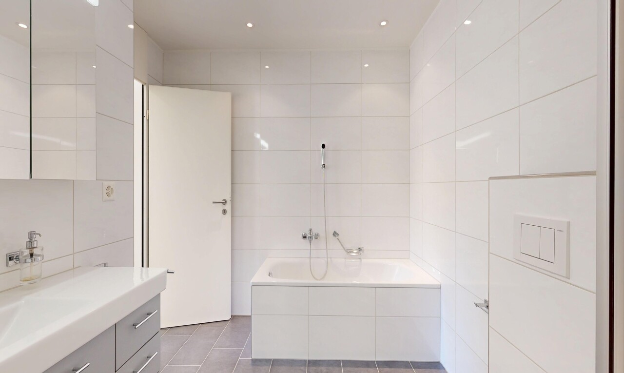 salle de bains avec mur en carrelage, tile wall, lavabo (ou coiffeuse selon le contexte), bain, et salle de bain complète