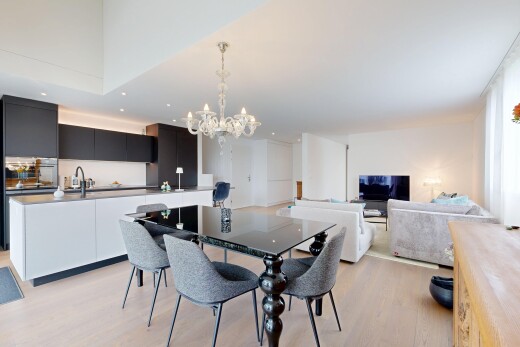 wohn- / esszimmer mit wood finish floor, holzfußboden, inside property, bemerkenswerter kronleuchter, und fernseher