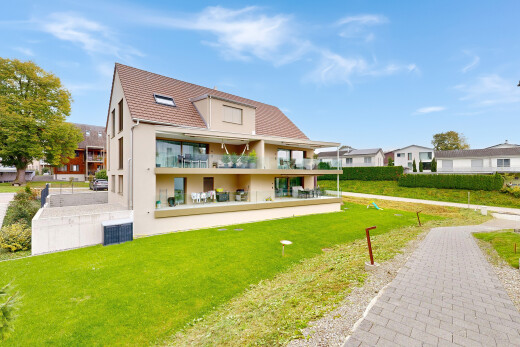 außenansicht mit rasen, day time, property visible, und stuckverkleidung