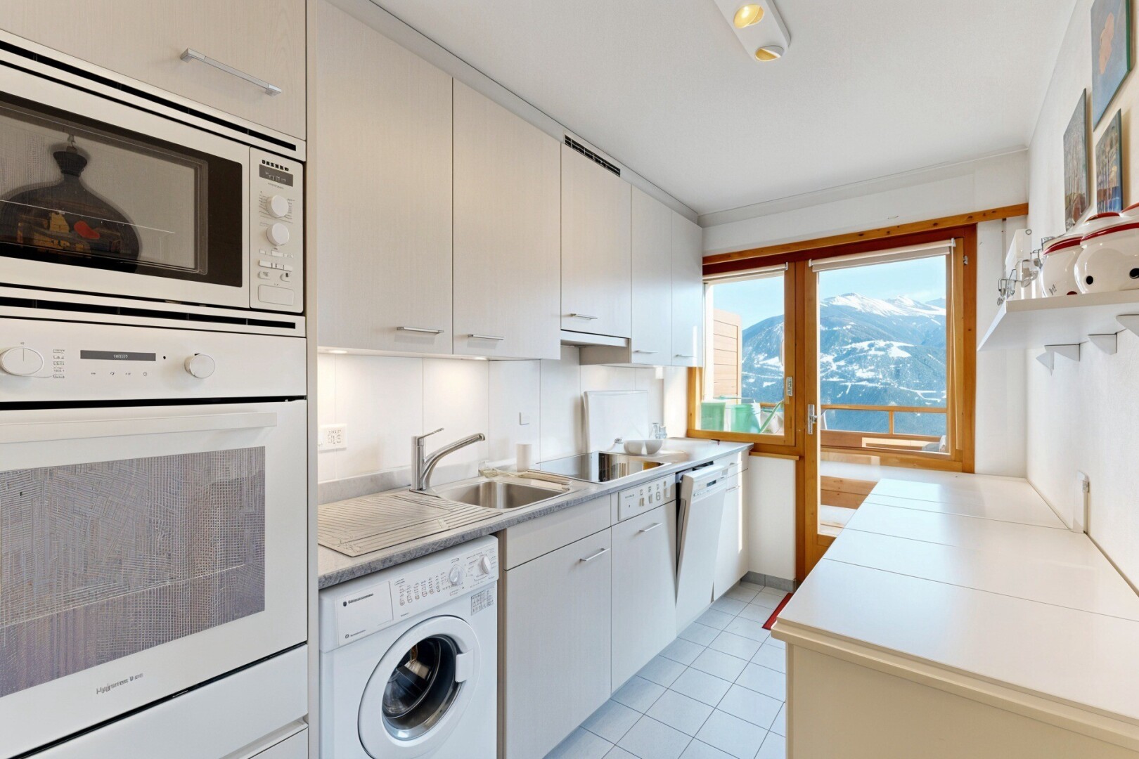 cuisine avec light countertops, plans de travail, lave-linge et sèche-linge, four, et micro-ondes