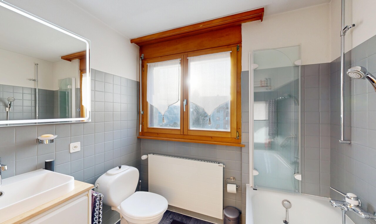 salle de bains avec salle de bain complète, radiateur, miroir, lavabo (ou coiffeuse selon le contexte), et tile wall