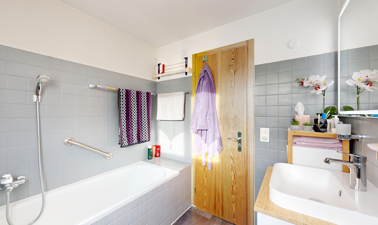 salle de bains avec bain, évier, lavabo (ou coiffeuse selon le contexte), mur en carrelage, et tile wall