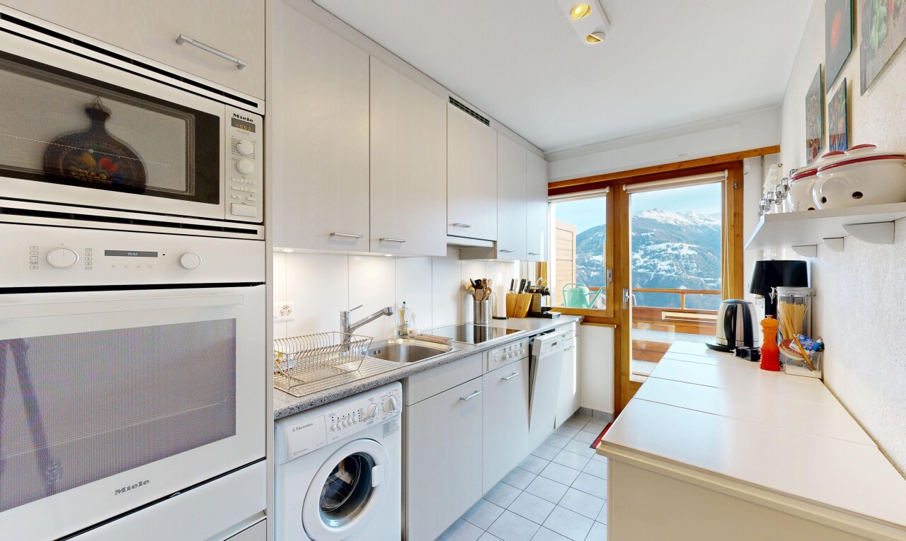 cuisine avec light countertops, plans de travail, lave-linge et sèche-linge, four, et micro-ondes