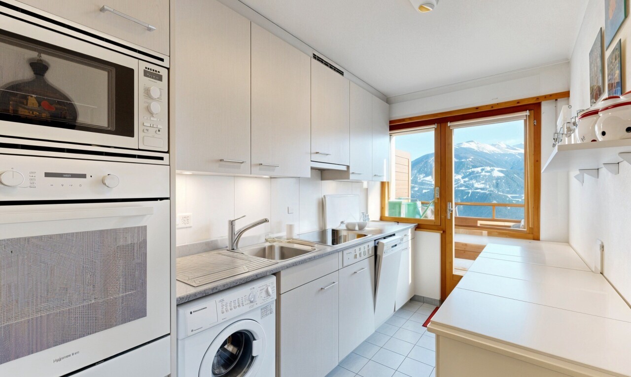 cuisine avec light countertops, plans de travail, lave-linge et sèche-linge, four, et micro-ondes
