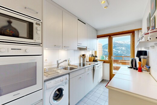 cuisine avec light countertops, plans de travail, lave-linge et sèche-linge, four, et micro-ondes