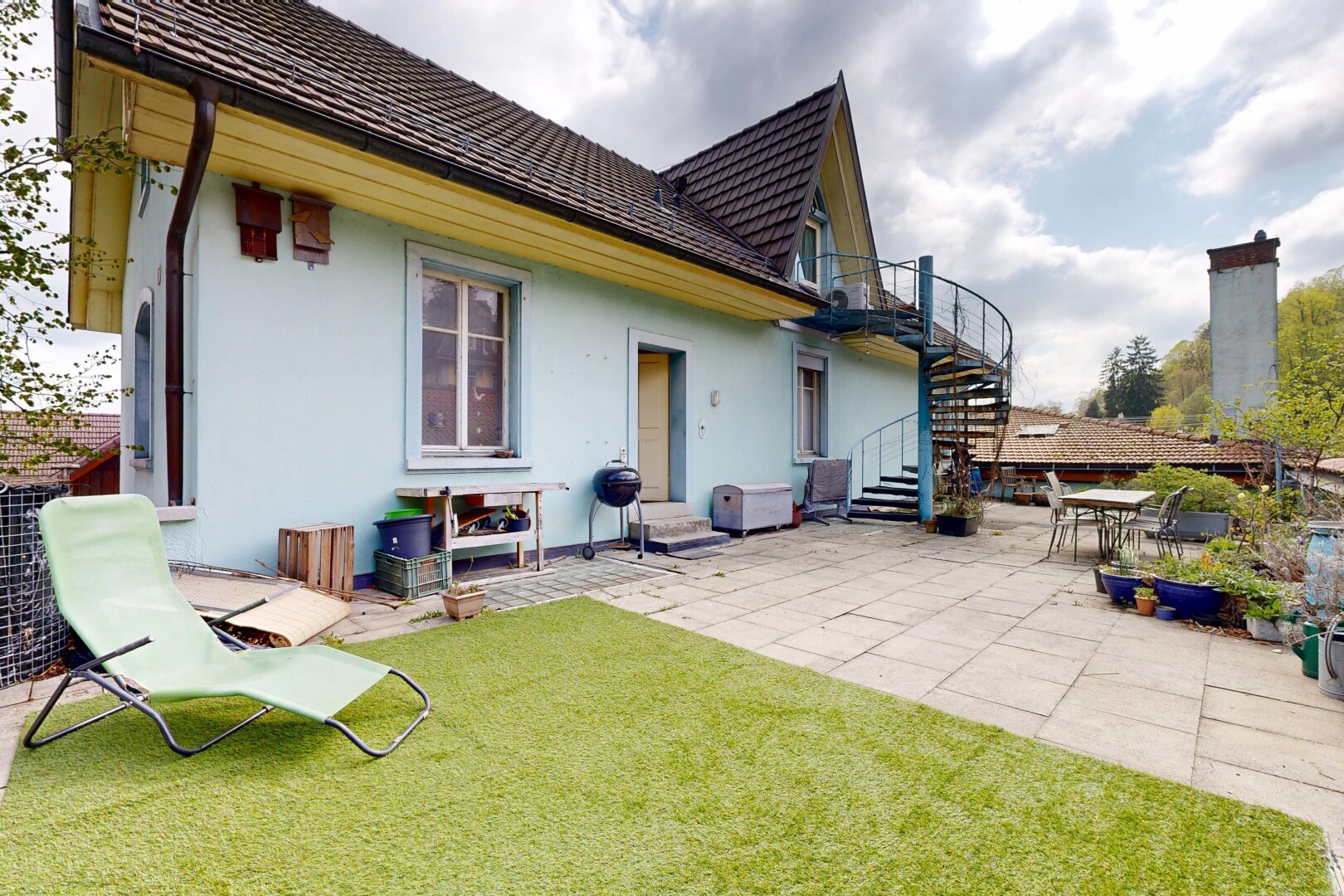 façade avec terrasse, pelouse, property visible, escaliers, et bardage en stuc