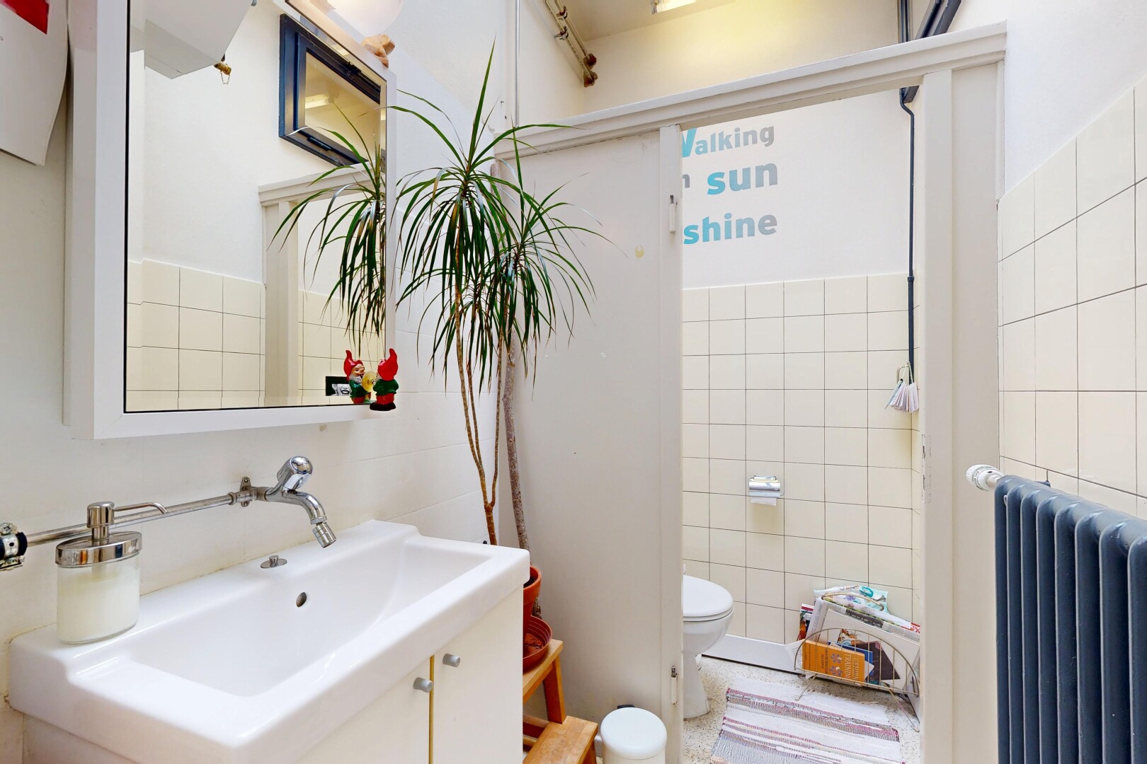 salle de bains avec radiateur, lavabo (ou coiffeuse selon le contexte), miroir, toilette, et inside property