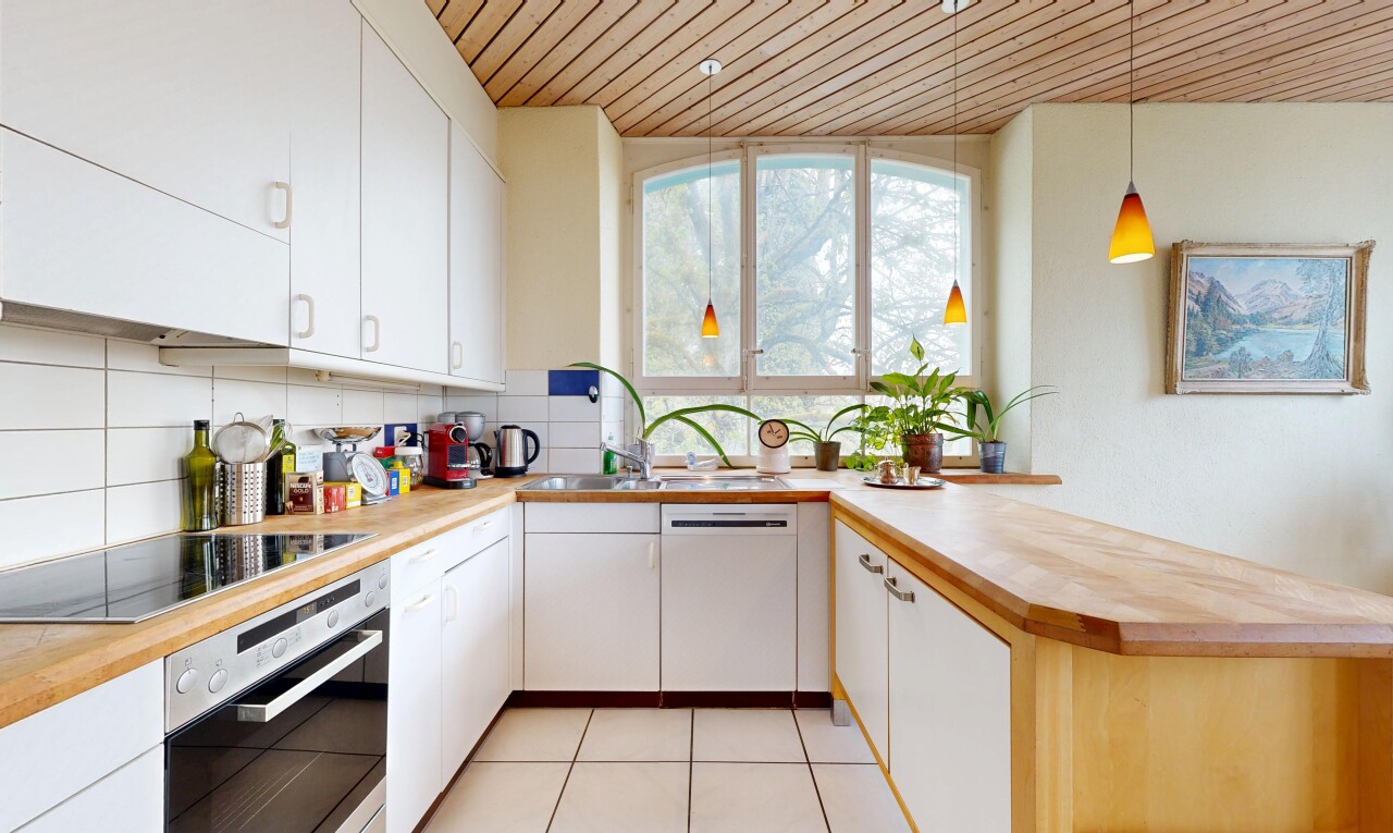 cuisine avec light countertops, four, plafond en bois, wood ceiling, et armoires blanches