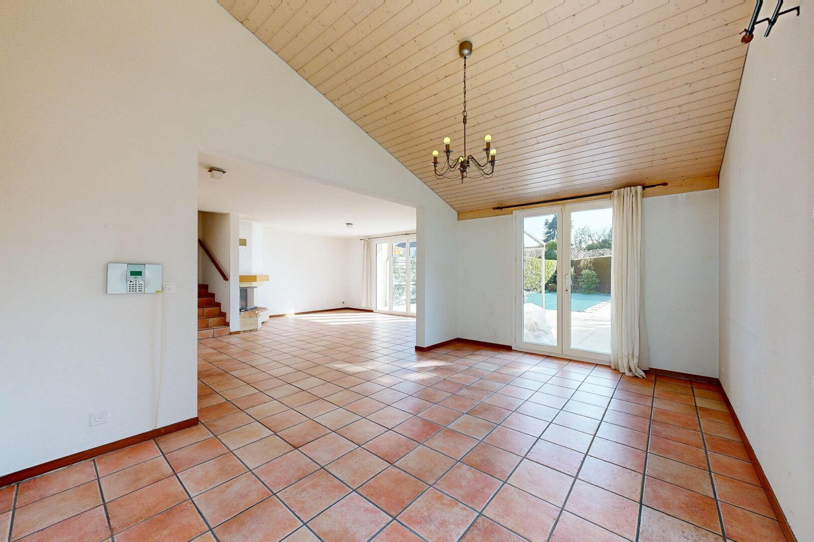 leerer raum mit inside property, hohe decke, high ceiling, bemerkenswerter kronleuchter, und light floor
