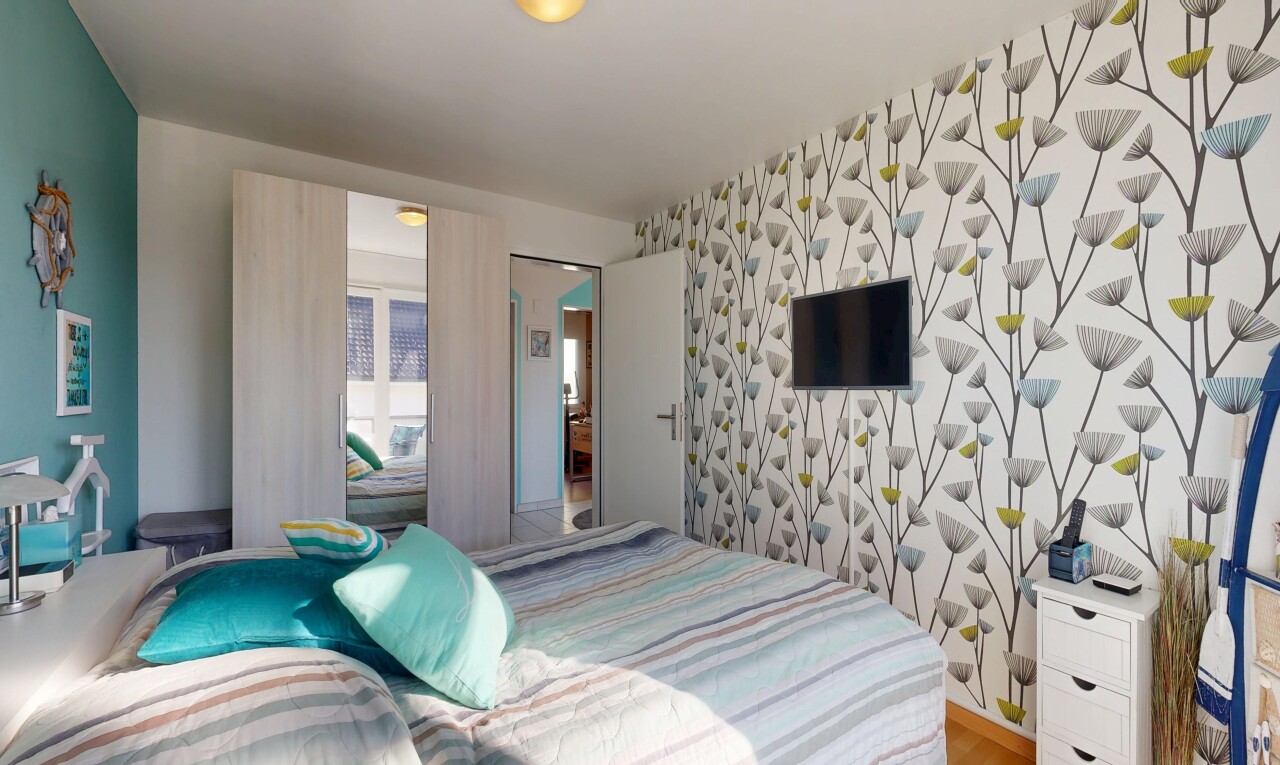 zimmer / schlafzimmer mit wallpaper wall, tapetenwand, fernseher, inside property, und accent wall