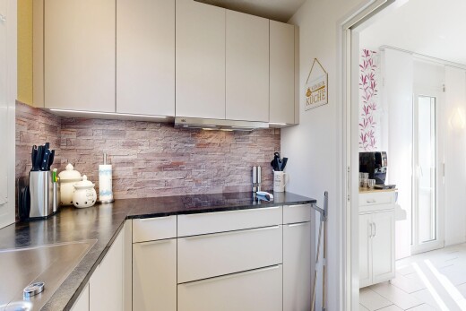 küche mit inside property, arbeitsplatten, dark countertops, gipskartonwand, und drywall