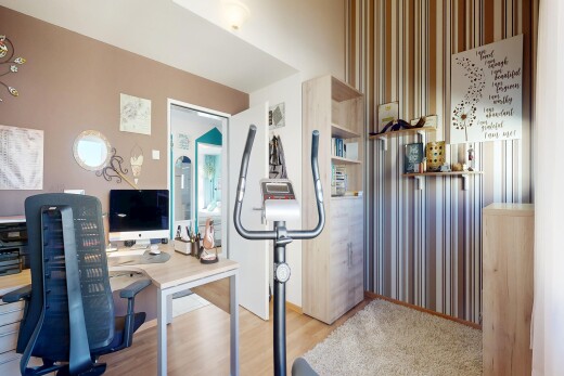 zimmer / schlafzimmer mit holzfußboden, wood finish floor, fernseher, inside property, und light floor