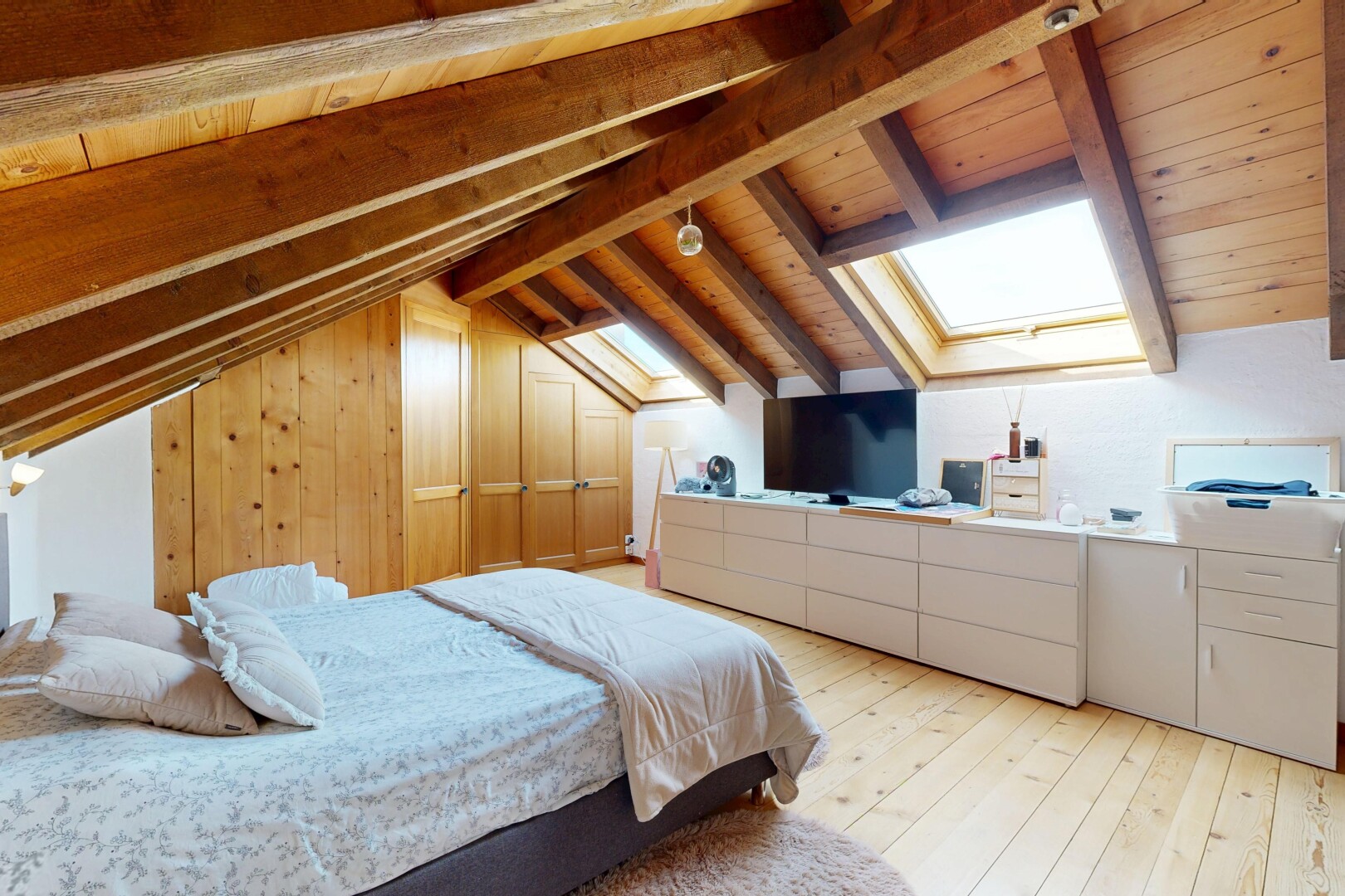 zimmer / schlafzimmer mit dachfenster, vaulted ceiling, dachschräge, fernseher, und beamed ceiling