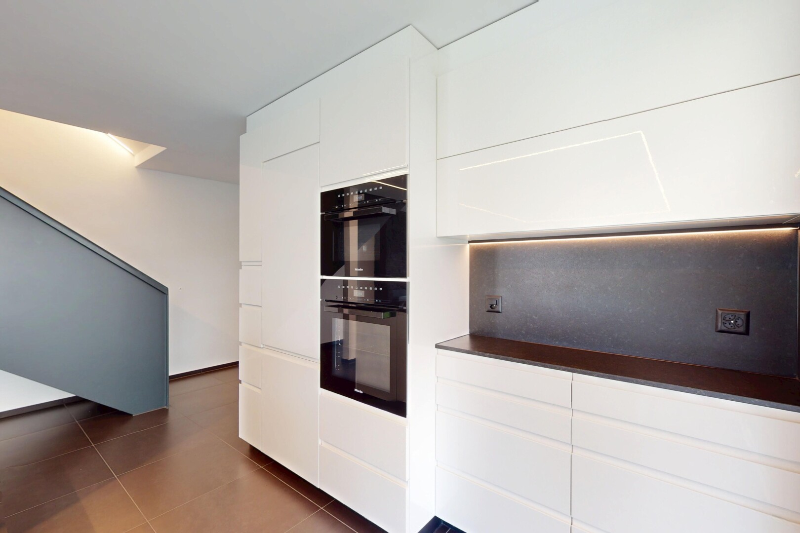 cuisine avec armoires blanches, plans de travail, four double, tile floor, et sol en carrelage