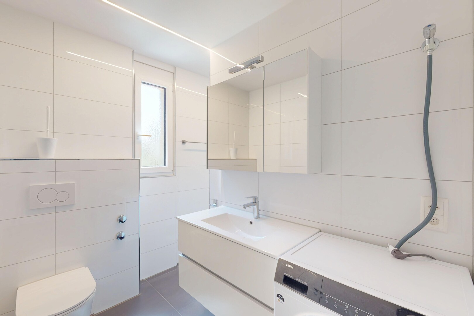 salle de bains avec miroir, mur en carrelage, tile wall, lavabo (ou coiffeuse selon le contexte), et inside property