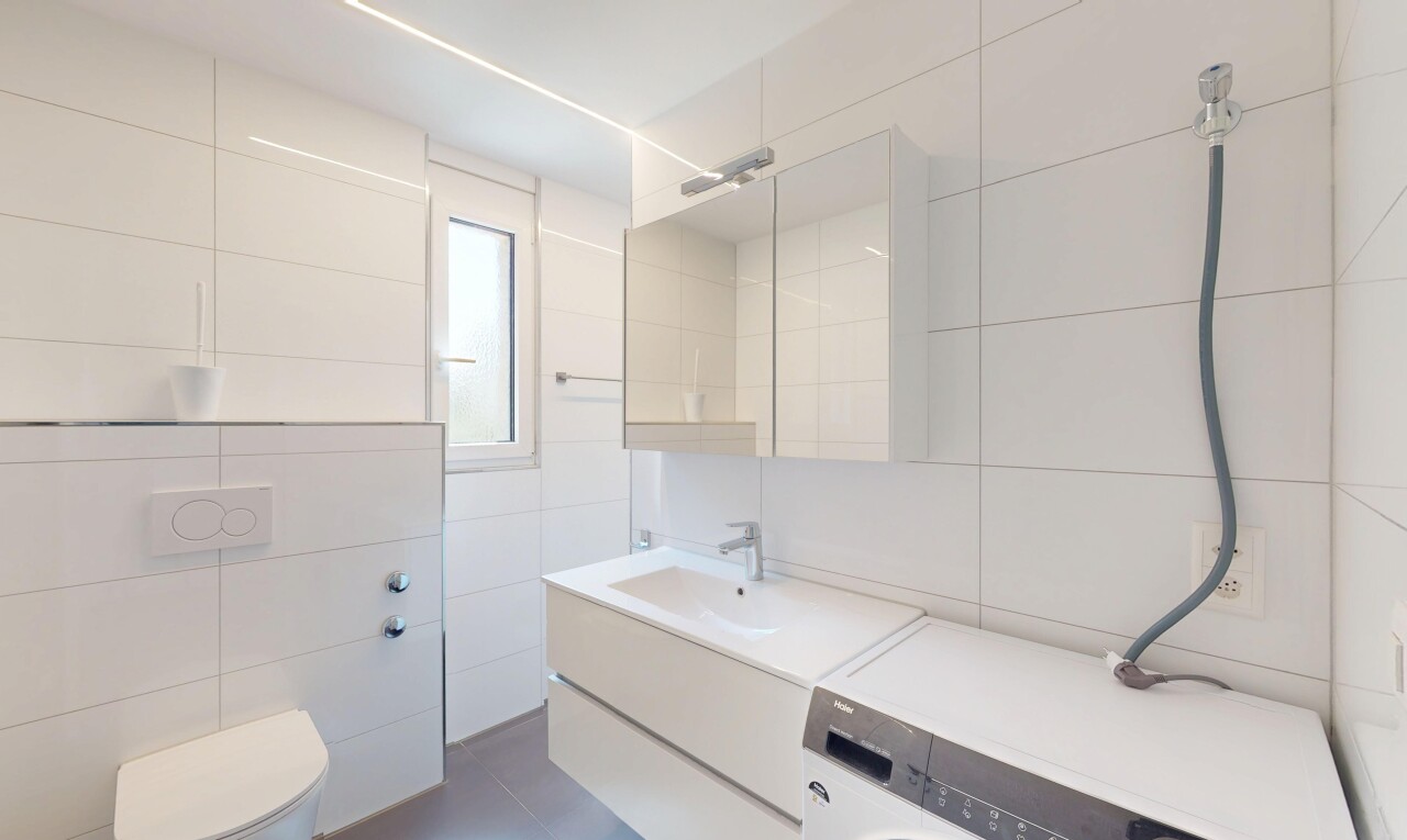 salle de bains avec miroir, mur en carrelage, tile wall, lavabo (ou coiffeuse selon le contexte), et inside property