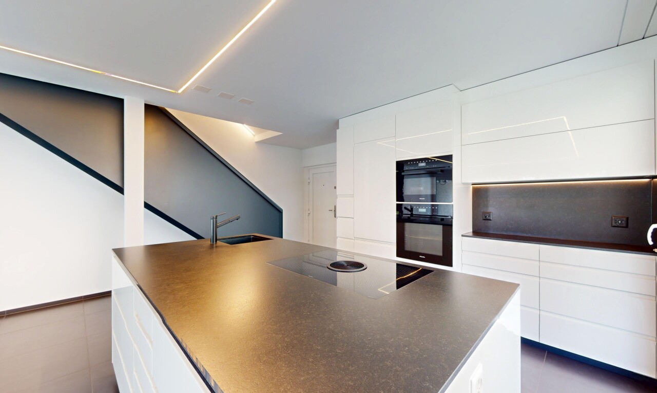 cuisine avec armoires blanches, plans de travail, drywall, cloison sèche, et plaque de cuisson