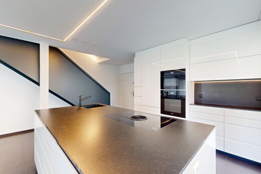 cuisine avec armoires blanches, plans de travail, drywall, cloison sèche, et plaque de cuisson