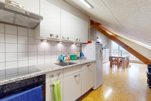 cuisine avec hotte, plafond texturé, four, plaque de cuisson, et évier