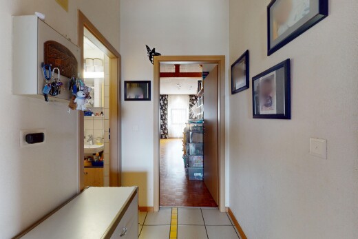 couloir avec lumière naturelle, plinthes murales, sol en carrelage, et cloison sèche