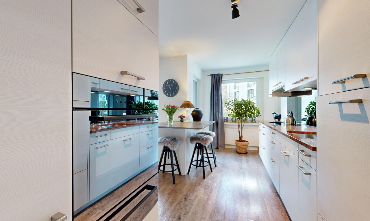 küche mit weiße schränke, white cabinets, inside property, light floor, und holzfußboden