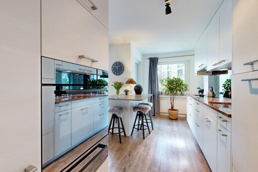 cuisine avec armoires blanches, white cabinets, inside property, light floor, et sol en finition bois